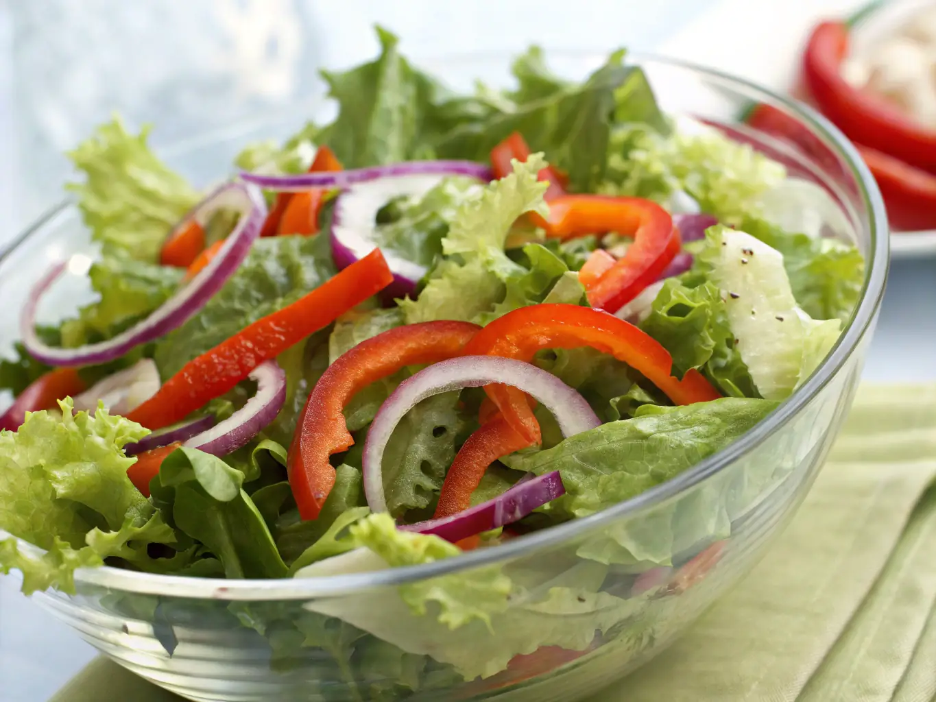 A vibrant image of a fresh garden salad with various vegetables and dressing, showcasing a healthy side option at Swiss Chalet.